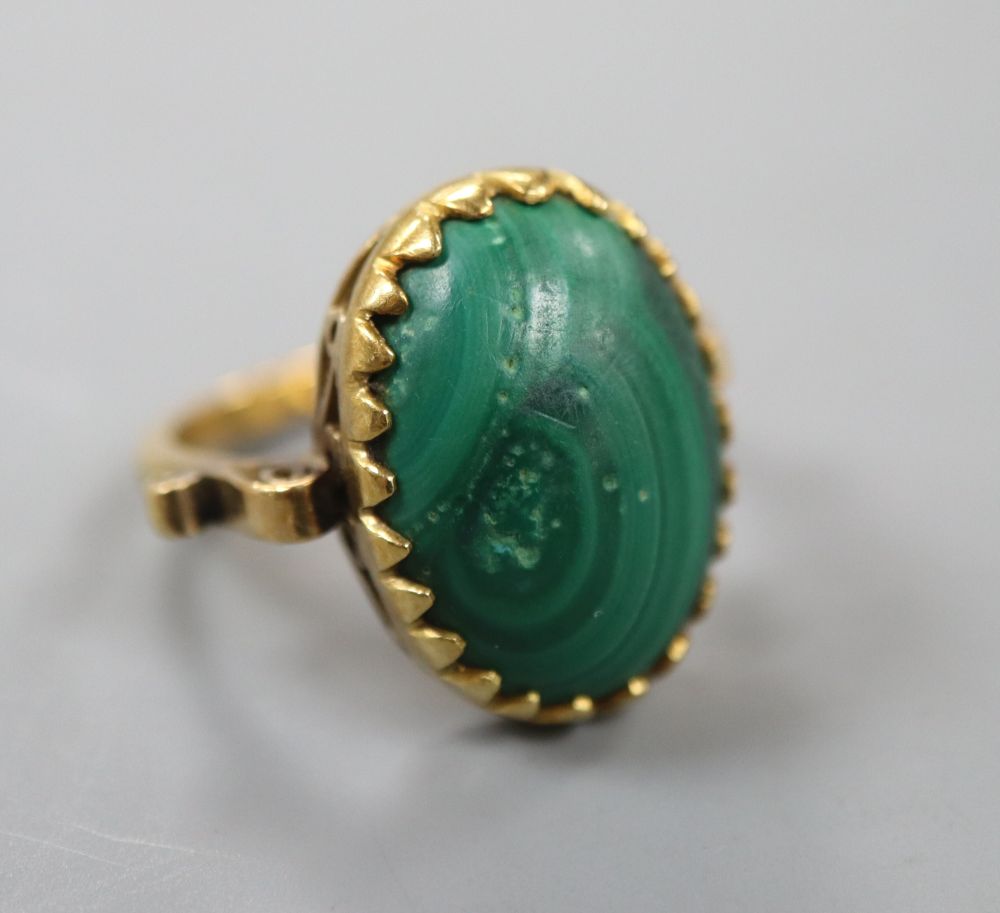 An 18k and oval cabochon malachite set dress ring, size N, gross 7.1 grams.